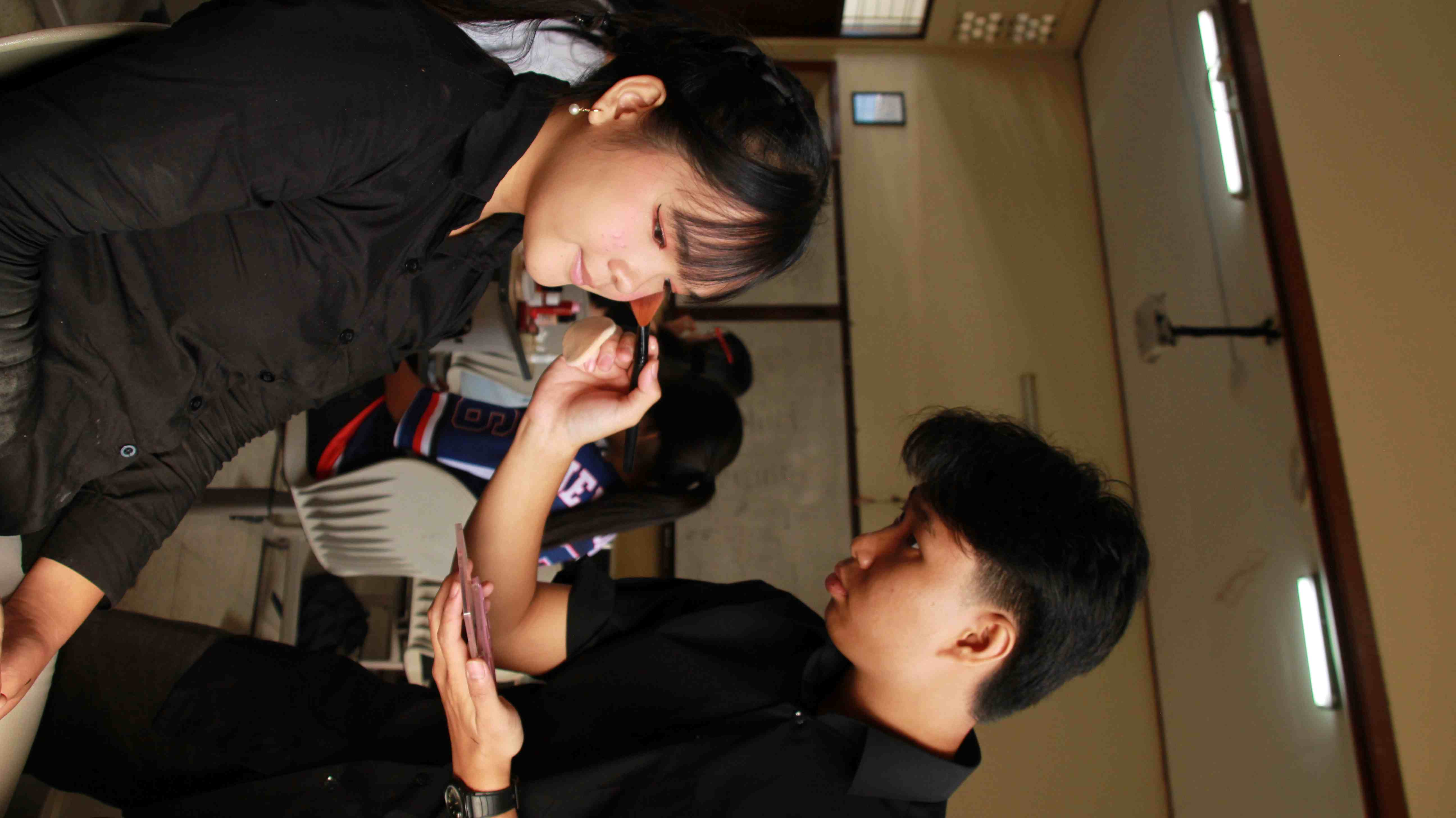 Designer melakukan make up model